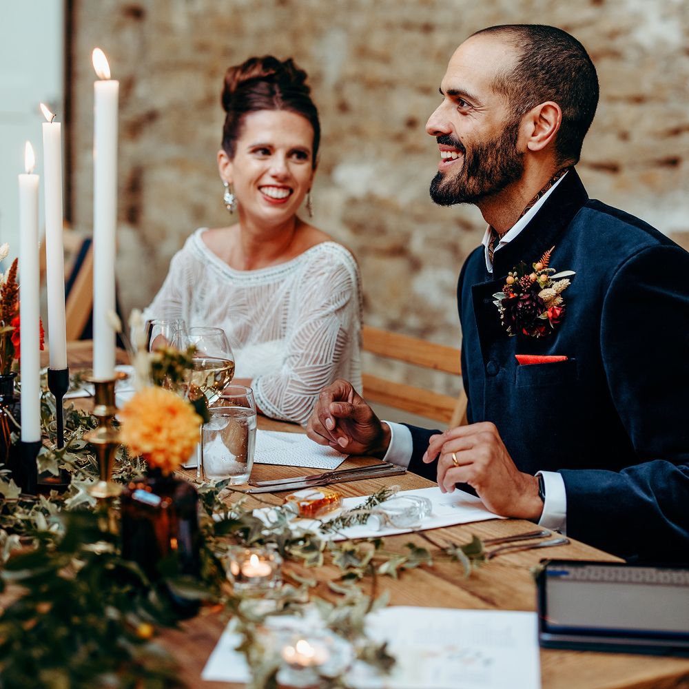 Bride & groom laugh together during wedding reception 
