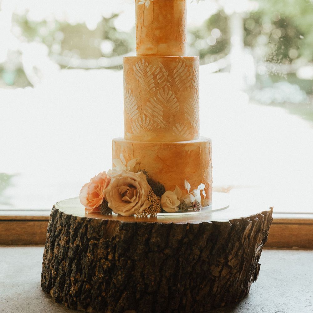 Pink boho rustic three tiered wedding cake with pink rose decoration