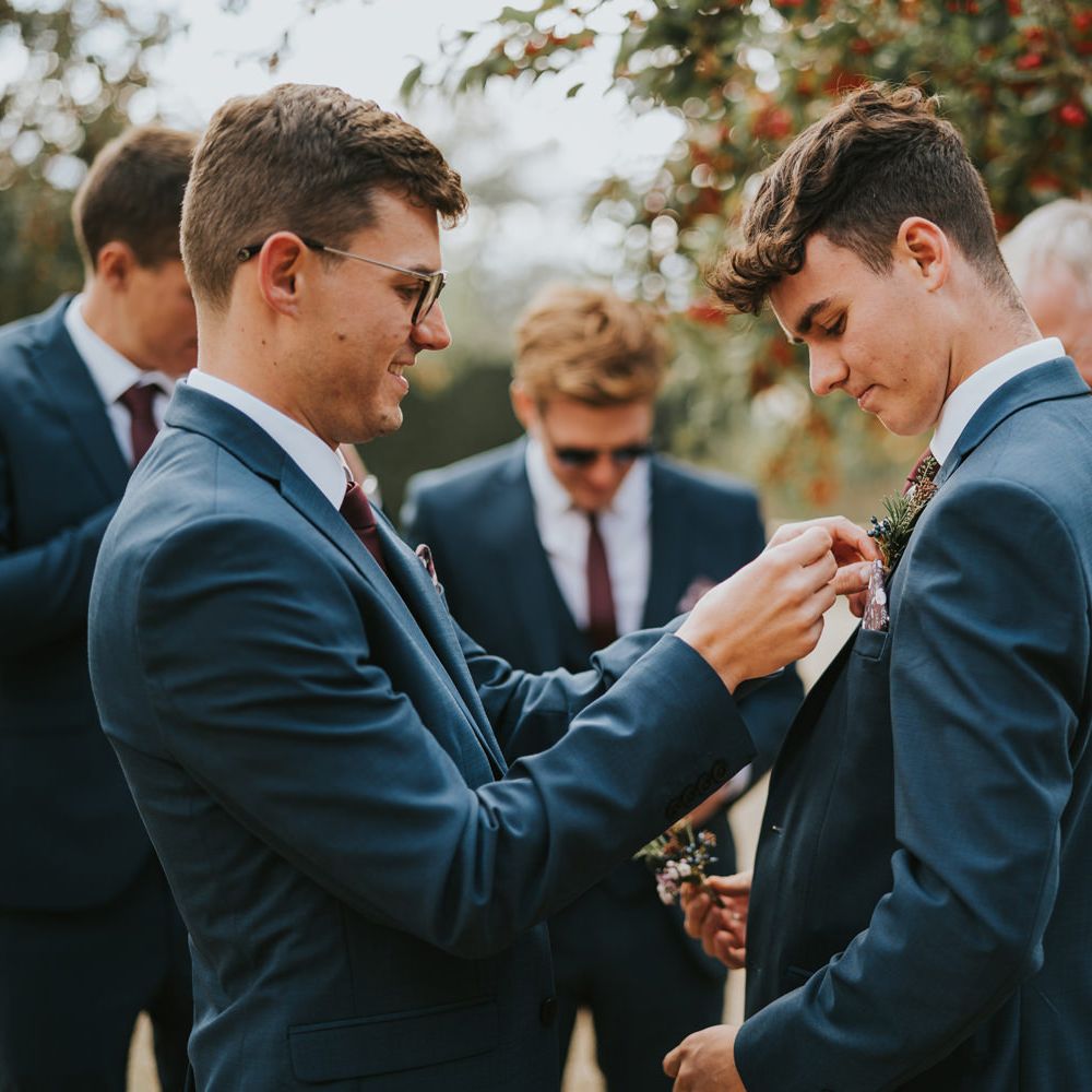 Groom fixes pocket square of a Groomsmen 