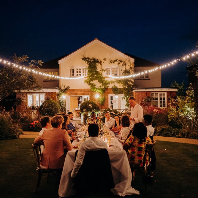 Festoon lights hanging in the garden of the intimate wedding reception 