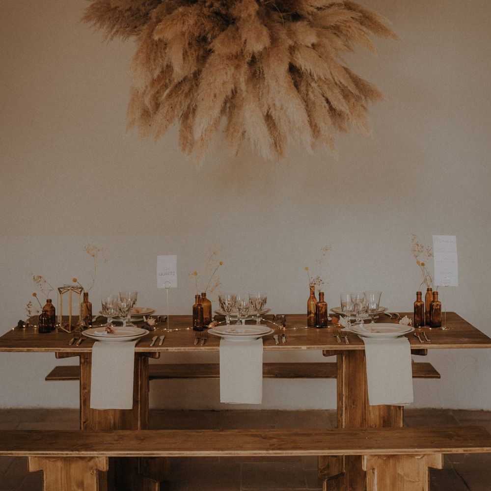 Minimalist wedding reception with wooden table and pampas grass installation