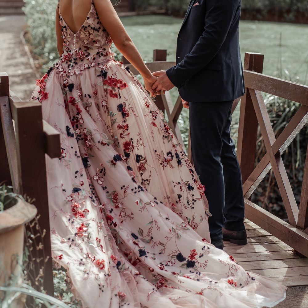 Bride & groom stand on wooden bridge on their wedding day