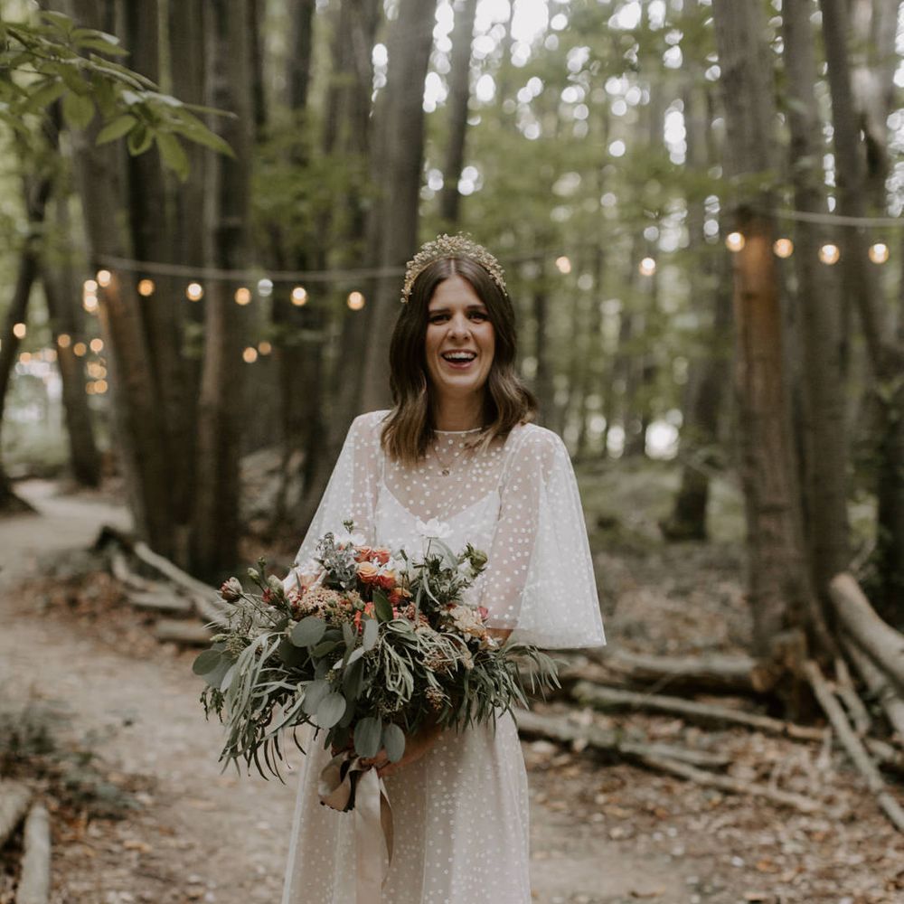 Bride stands with her bouquet outdoors on her wedding day