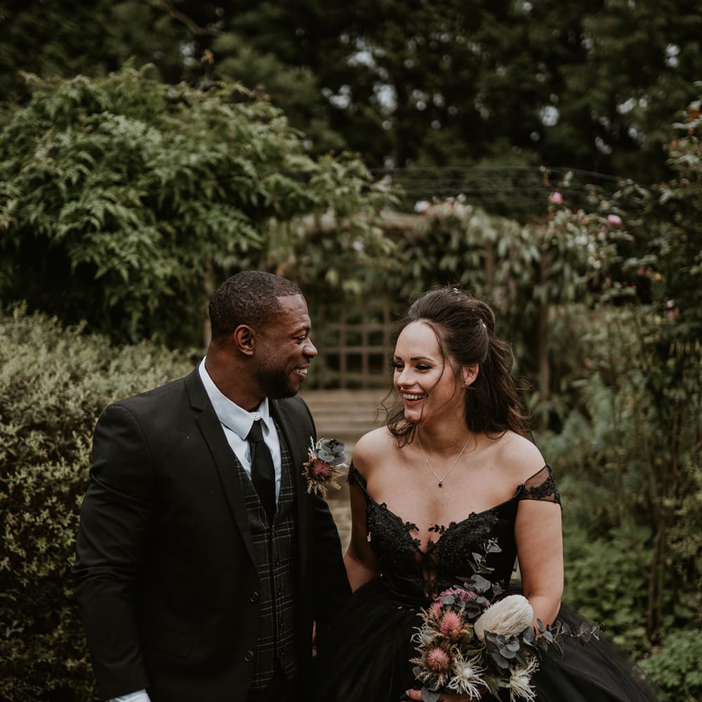 Bride & groom walk hand in hand with one another on their wedding day