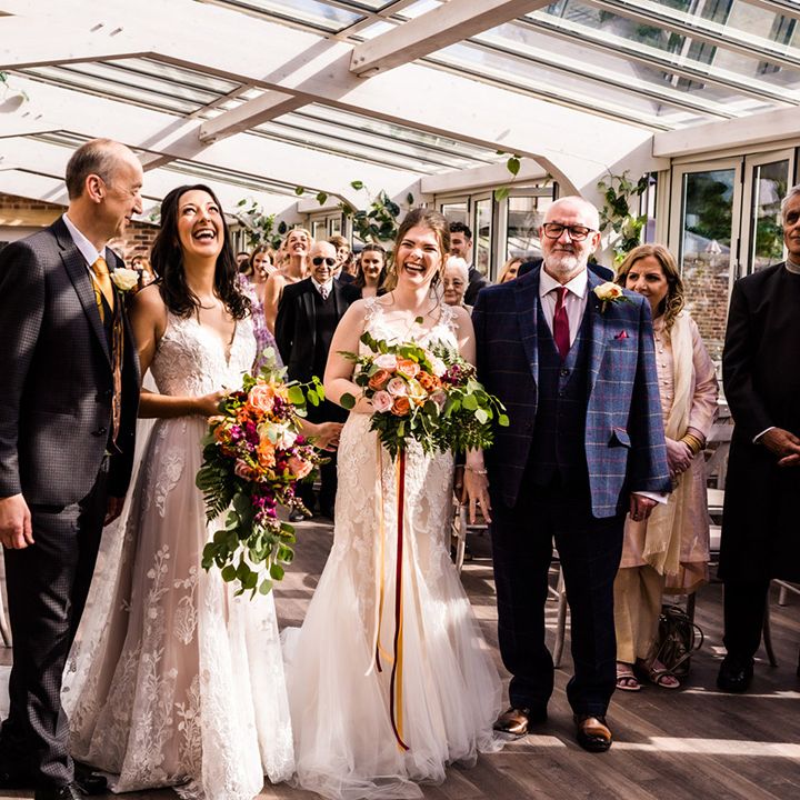 Brides stand with their fathers at Foxtail Barns wedding venue for their ceremony