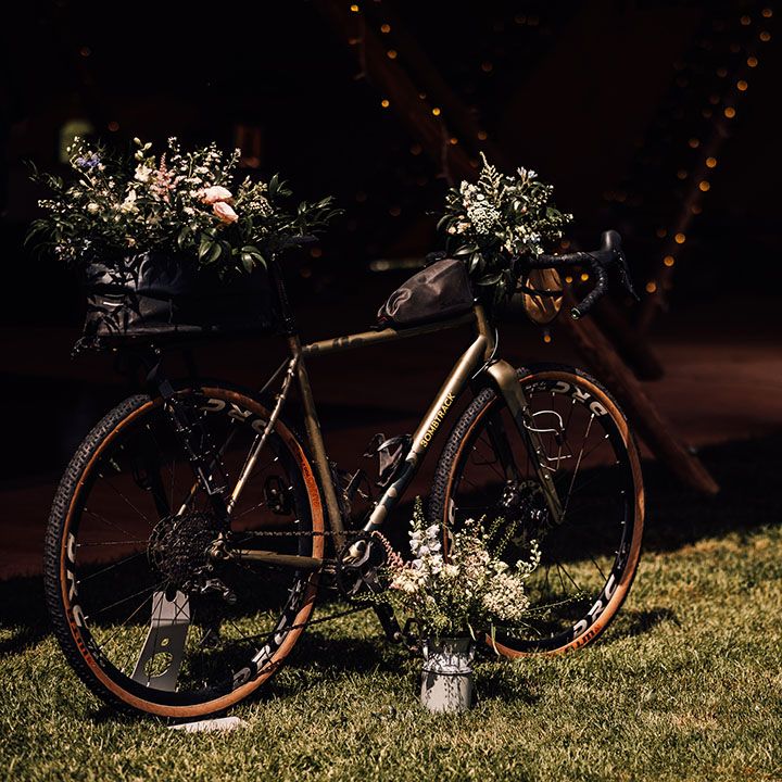 Bike decorated with wedding flowers and wooden pallet order of the day sign 