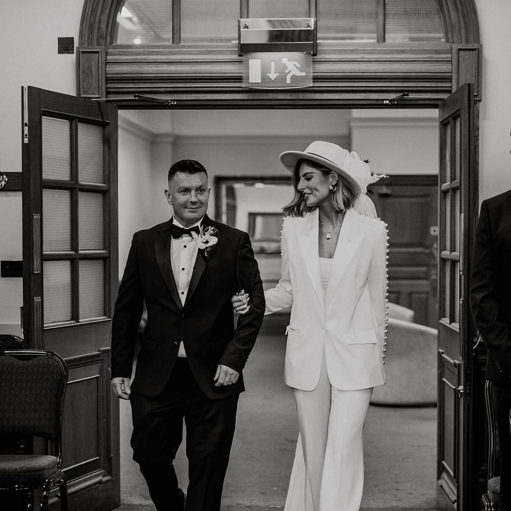Black tie wedding attire for town hall wedding with bride in white pearl trouser wedding suit 