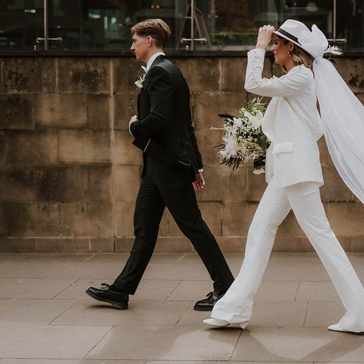 Bride and groom walk together outside their wedding venue 