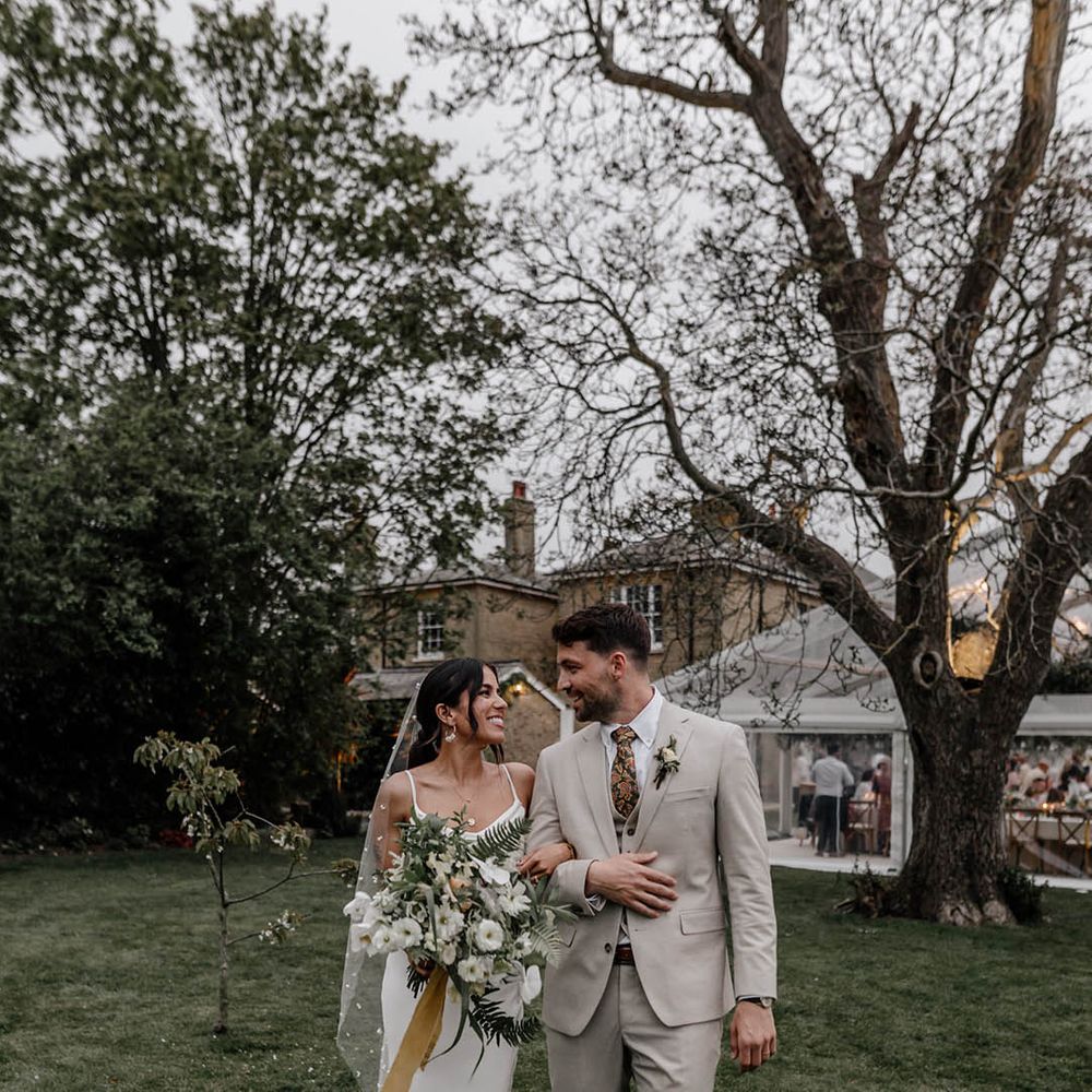 Home wedding with clear glass marquee and bride in a satin wedding dress and pearl veil 