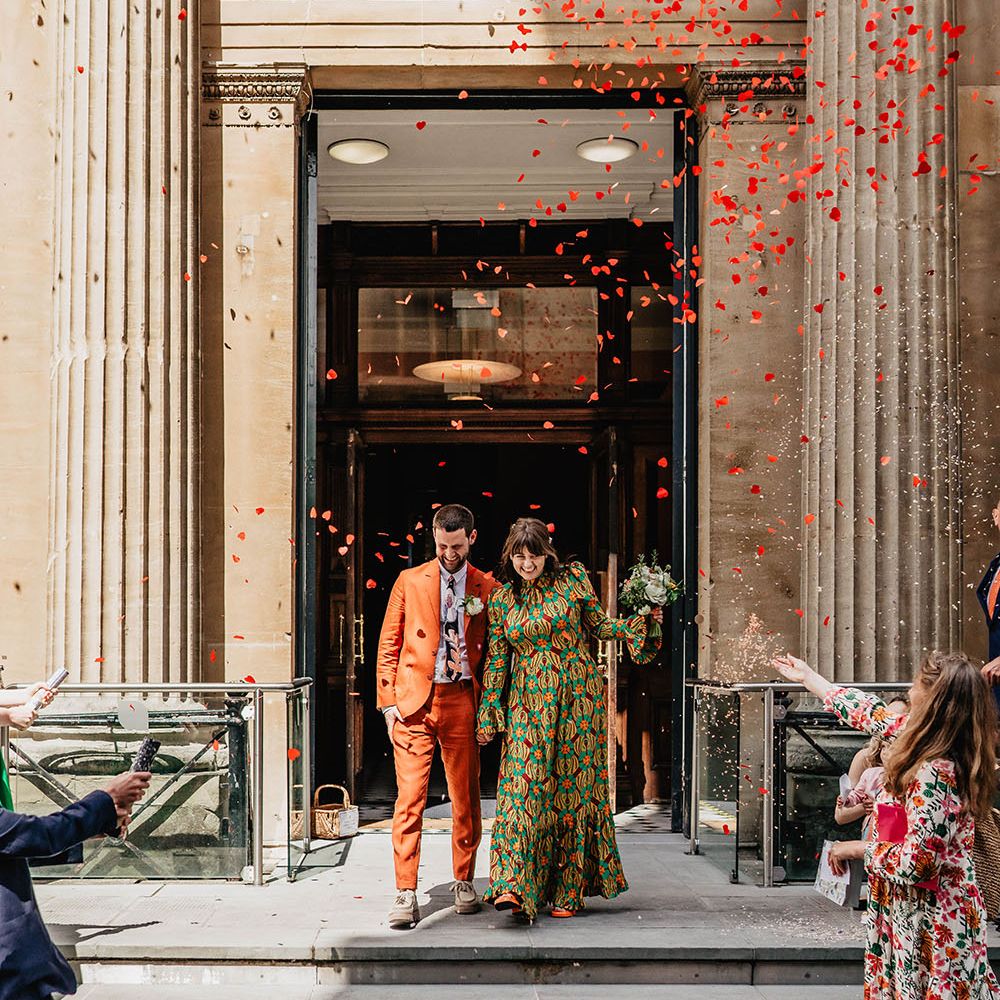 Heart shaped confetti explodes from cannon around bride & groom as they leave Bristol Register Office 