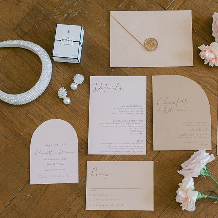 Neutral wedding stationery suite flatlay with gold wax seal by Sweet Ophelia Designs with flowers and bridal accessories 