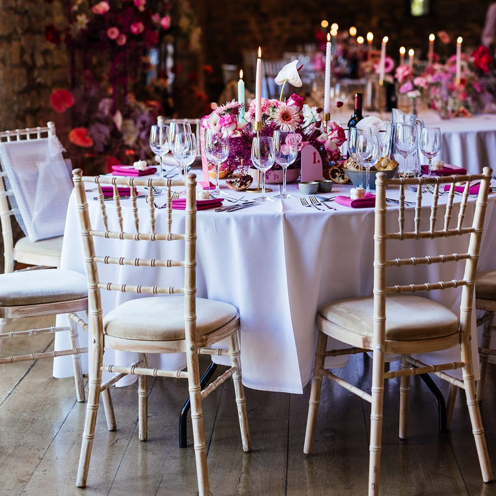 Eco candle wedding favours, bright pink fabric napkins and bright floral centrepiece for modern tablescape look
