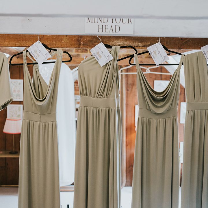 Bridesmaid's sage green dresses hanging up with personalised note