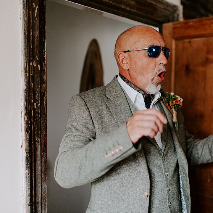 Bride's father sees her for the first time on wedding day wearing sunglasses and grey three-piece suit