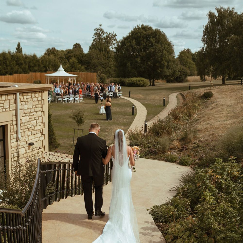 Bride and father of the bride walk hand in hand for the walk to the aisle 