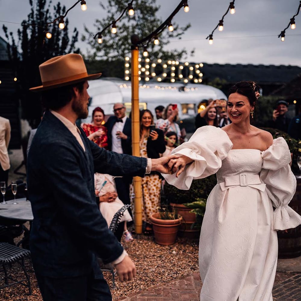The bride and groom have their first dance together outdoors 
