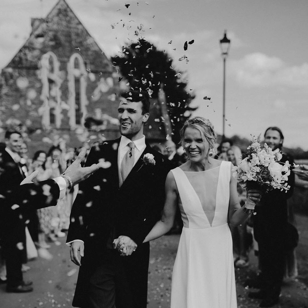 The bride and groom exit from their church ceremony to confetti 