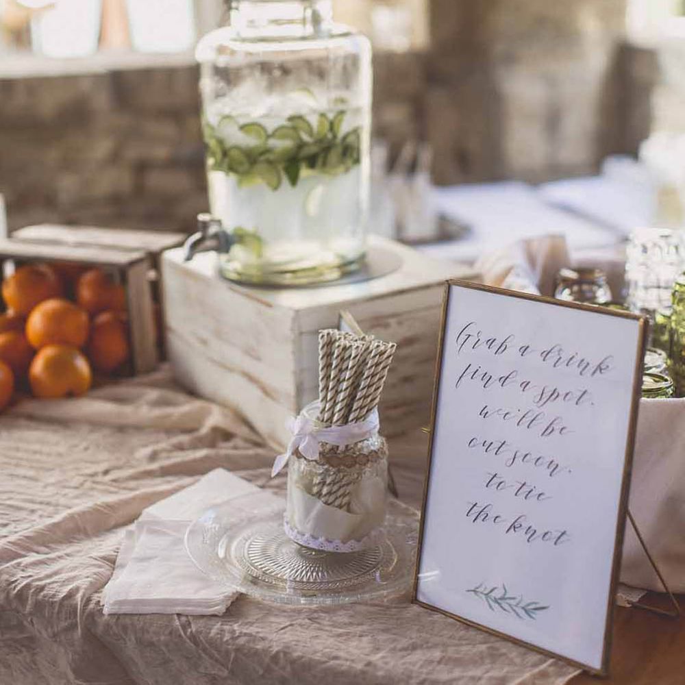 Large glass dispenser of water flavoured by cucumbers 