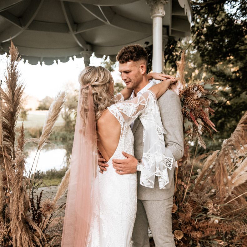 The bride shows off the open back detailing on Rue de Seine wedding dress 