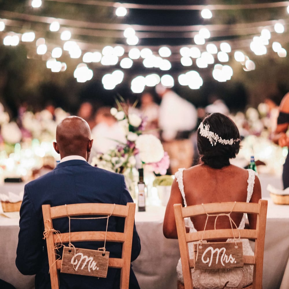 Outdoor country style wedding with Mr & Mrs signs for bride and grooms seating 
