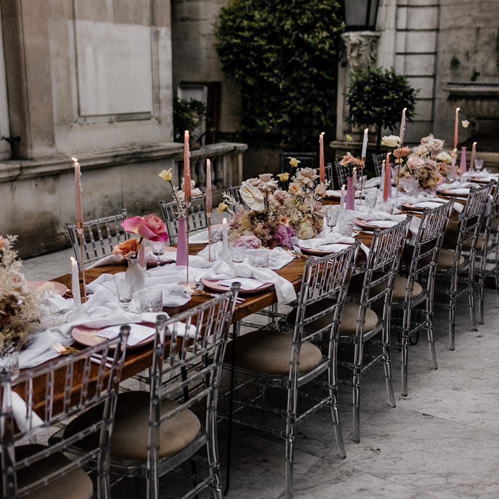 Intimate tablescape with pink taper candles and floral centrepiece table decor 