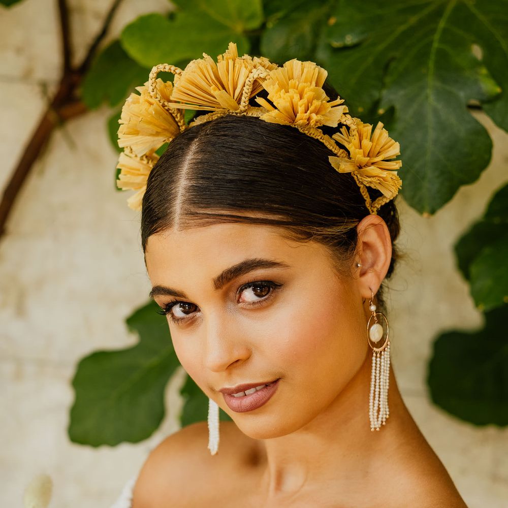 Bride in a strapless wedding dress with tassel earrings and yellow flower headband for fiesta theme wedding