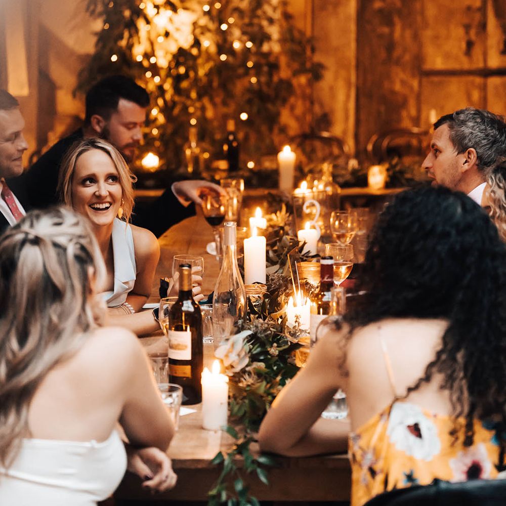 Wedding guests laugh and smile during reception