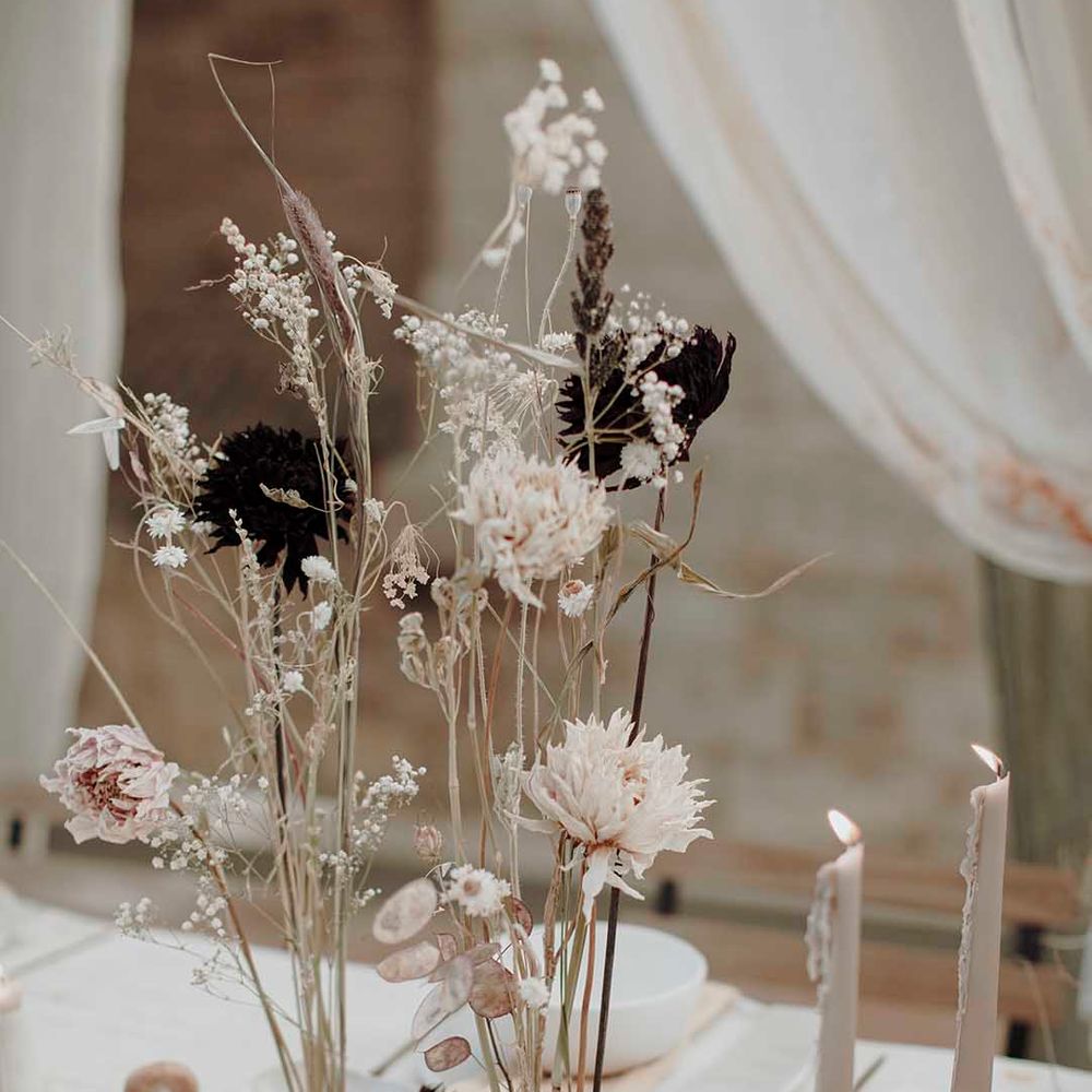 minimalist wedding table decor with taper candles and long dried flower stems in finger bowls 