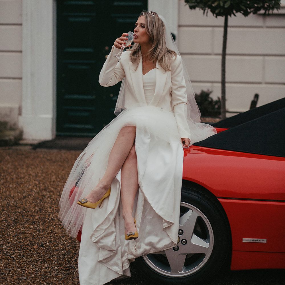 Bride sips champagne on red Ferrari and wears Zara jacket with yellow Manolo Blahniks 