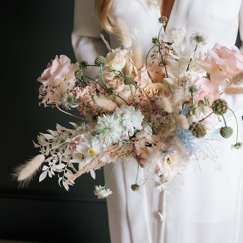 Bride's wedding bouquet of pastel summer flowers and pampas grass