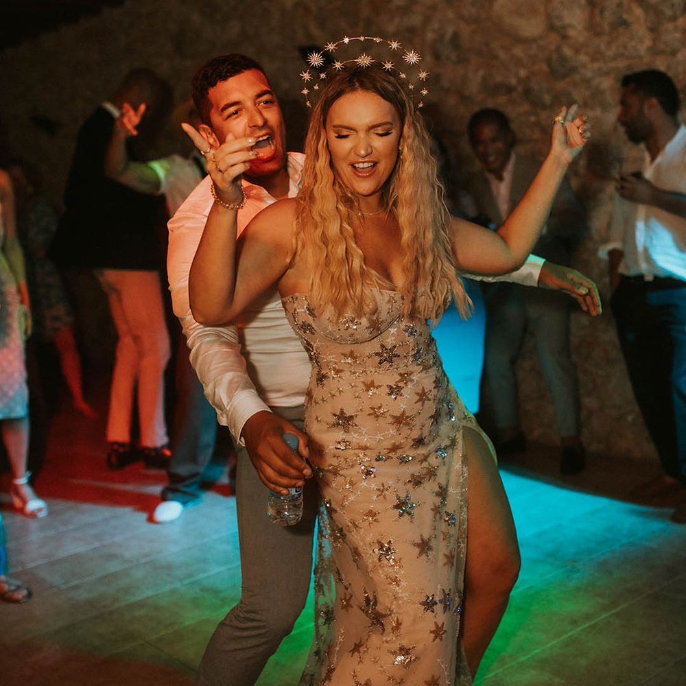 Bride in a celestial wedding dress and crown dancing at her evening reception 