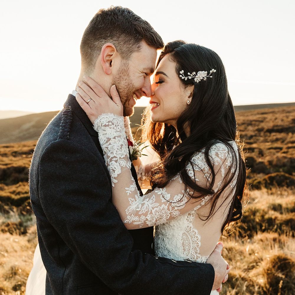 Bride & groom kiss outdoors on their wedding day during golden hour 
