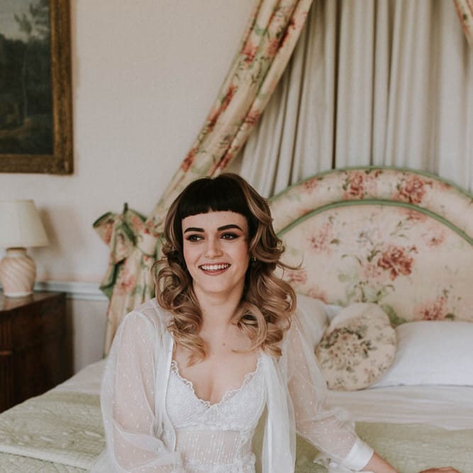 bride to be on her wedding morning in wedding lingerie sitting on the bridal bed