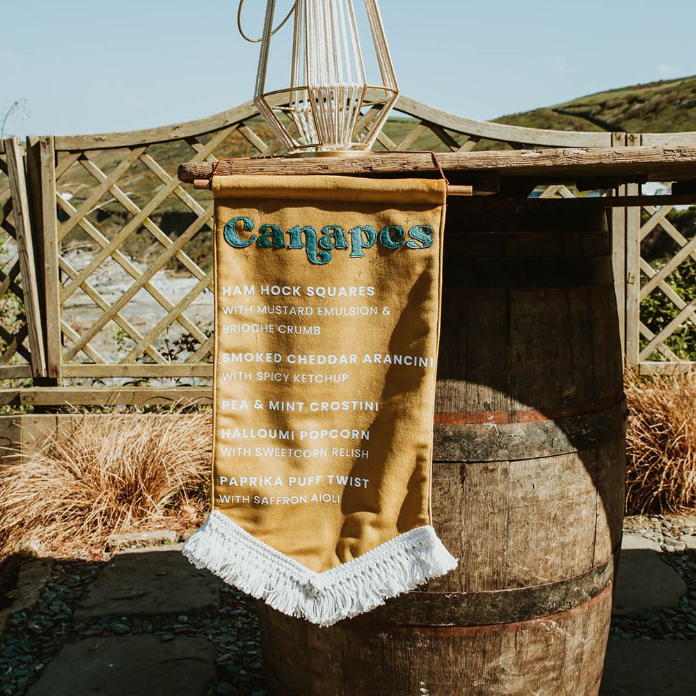 Mustard yellow fabric canapé menu sign for beach wedding 