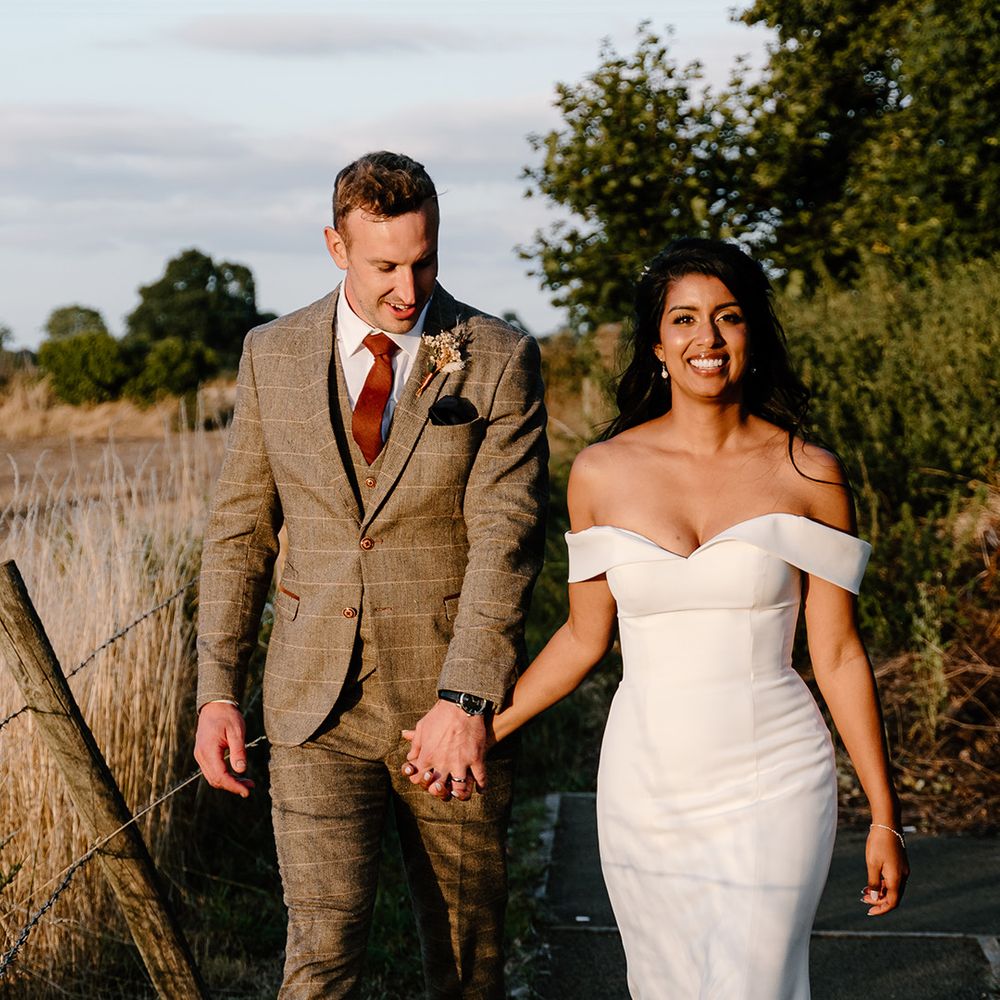 Golden hour couple portrait with the bride and groom walking in the sunshine 