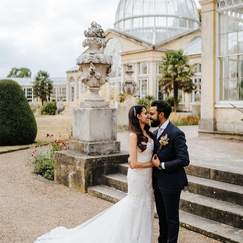 Bride & groom stand outside Syon Park before wedding reception in the Great Conservatory 