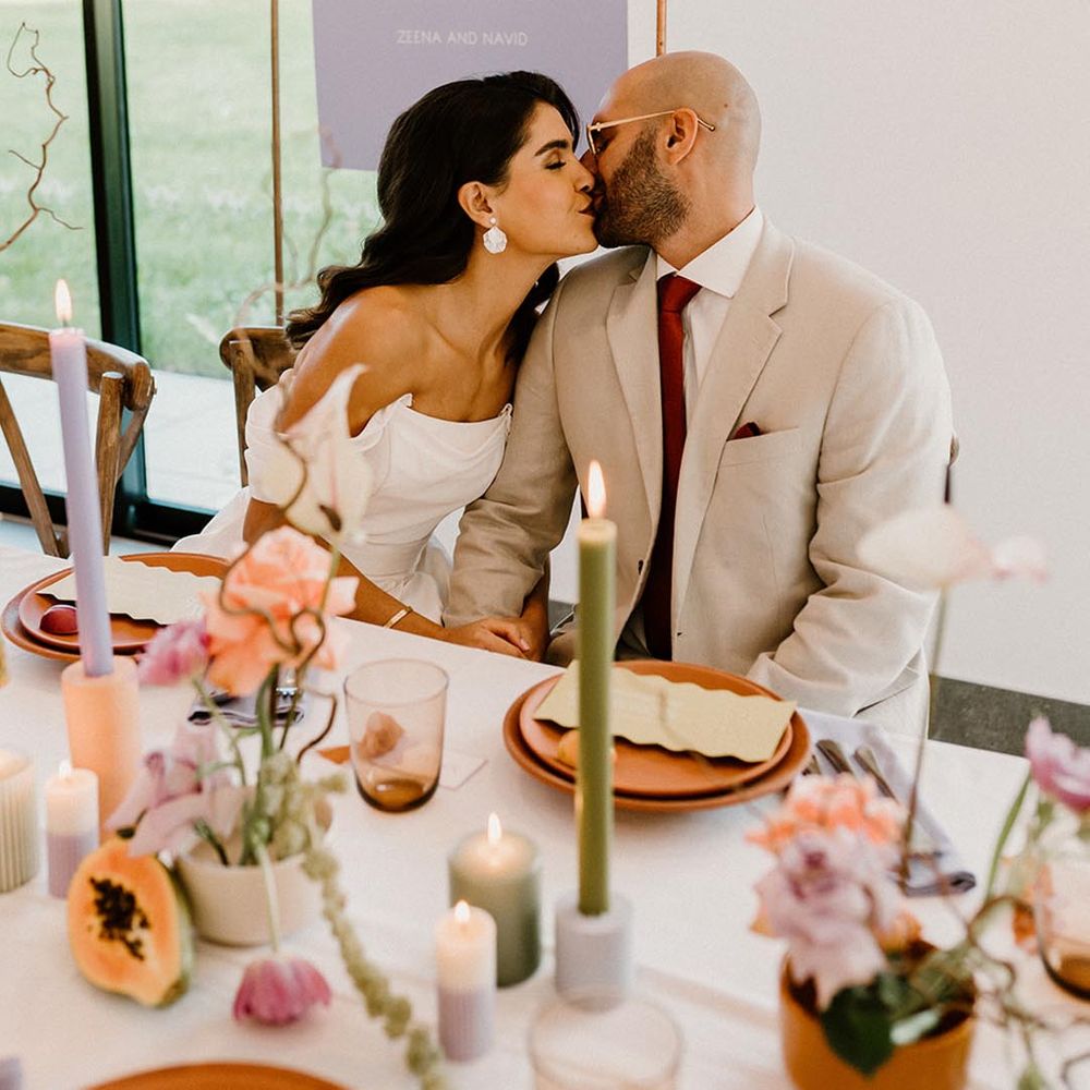 Lavender and white wedding sign with the bride and groom seated and kissing for their wedding reception 