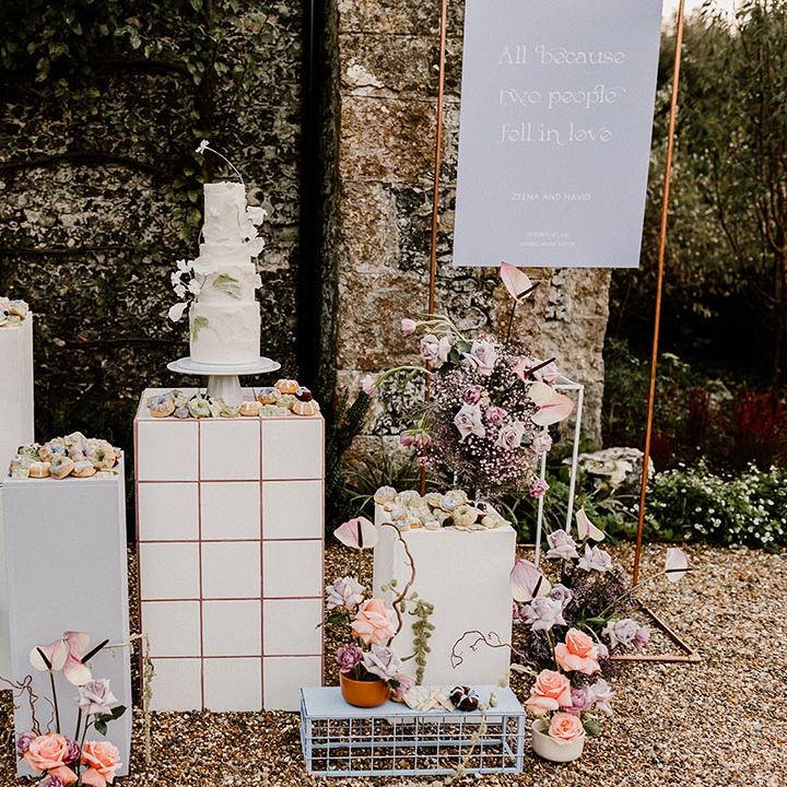Wedding dessert station with the luxe white iced wedding cake and lavender and white wedding sign