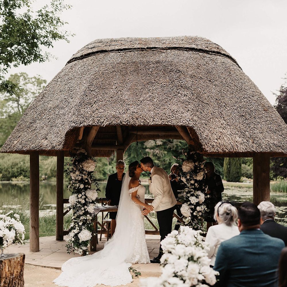 The bride and groom share their first kiss as a married couple at their outdoor ceremony at The Orangery in Kent