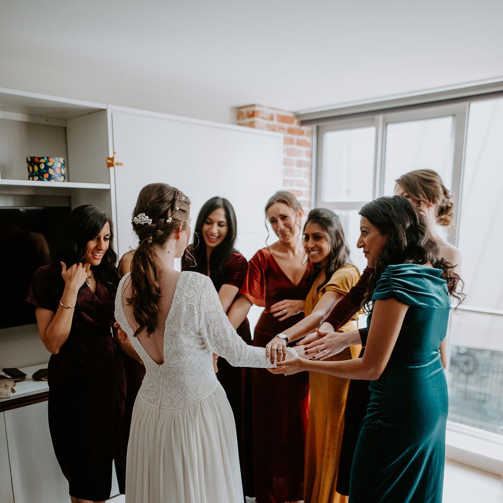 Bride in vintage long sleeved lace wedding dress with open back detail and bridal party in mismatched velvet bridesmaid dresses 
