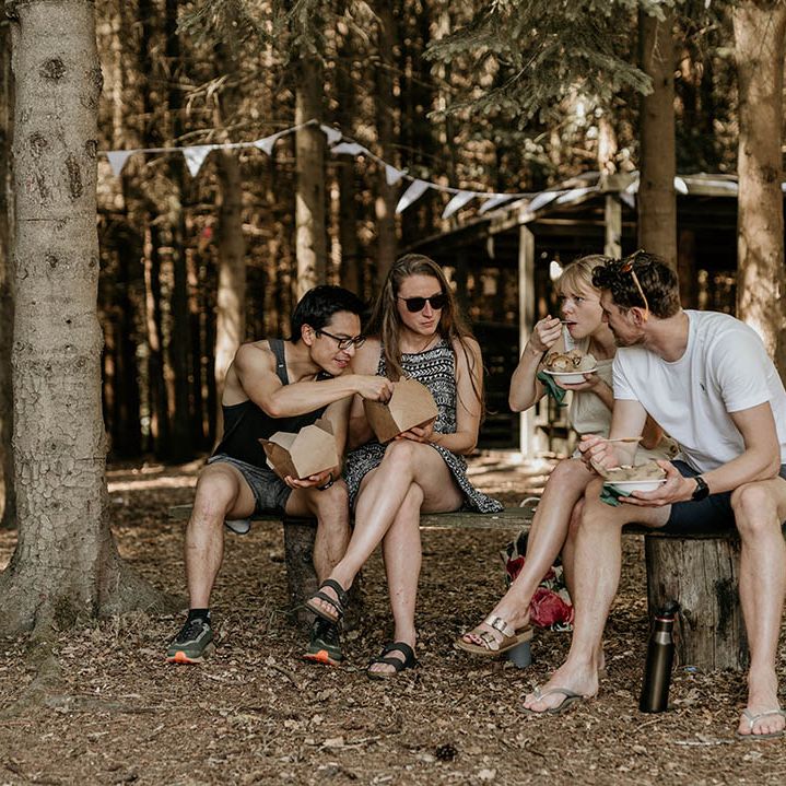 Wedding guests sit together and eat the wedding food together served from Mexican food trucks 