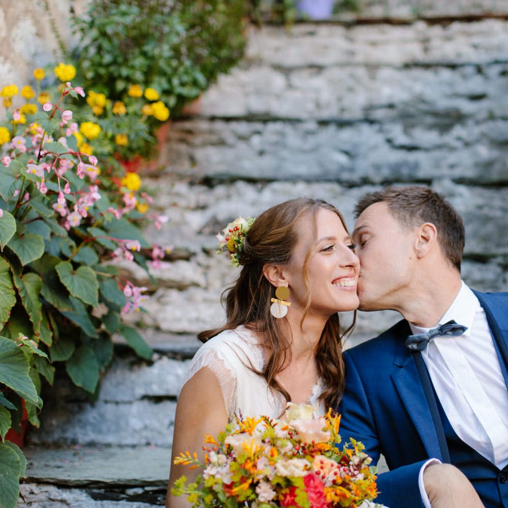 The groom kissing the bride on the cheek at their destination wedding in Greece