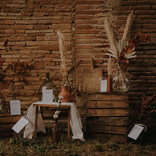 Rustic table plan with wooden crates, cutting boards and apothecary jars 