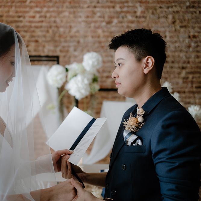 Brides reading their vows at their intimate Asian Lesbian wedding ceremony 