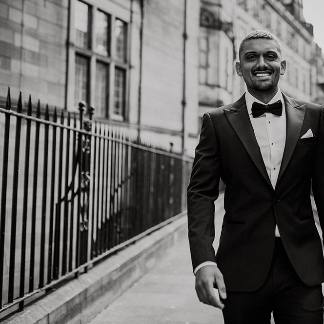 Stylish groom in a black tuxedo and bow tie 