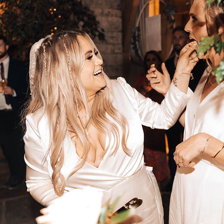 Bride feeds cake to her wife on their wedding day