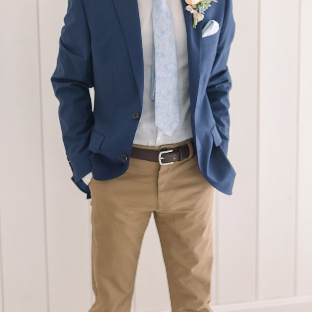 Groom in beige chinos, white shirt and navy blazer with pale blue paisley tie and pocket square