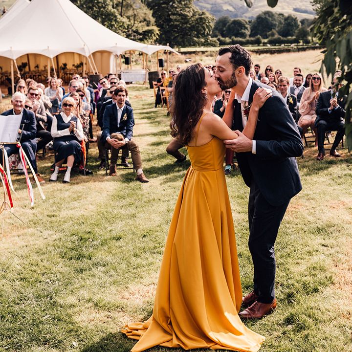 Bride & groom kiss outdoors