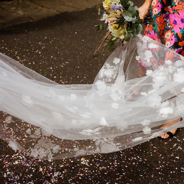 Bridesmaid helps lay out the bride's gorgeous 3D flower veil