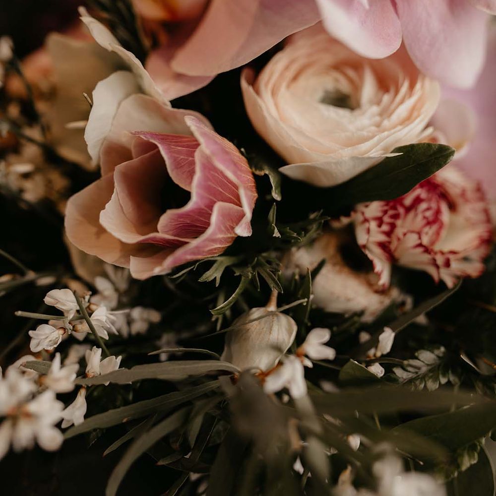 Mixed white and light pink floral bouquet with dark green foliage